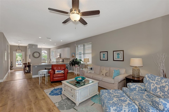 living room featuring light wood-type flooring and ceiling fan