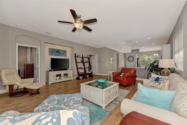 living room featuring ceiling fan, sink, and light hardwood / wood-style floors