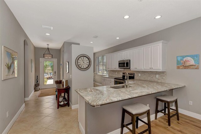 kitchen featuring sink, appliances with stainless steel finishes, kitchen peninsula, and a wealth of natural light