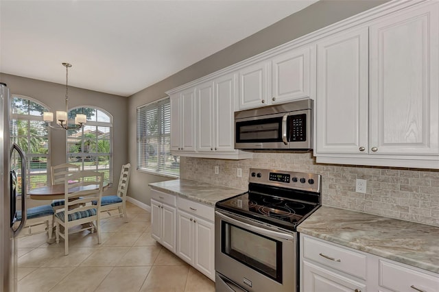 kitchen featuring tasteful backsplash, a chandelier, stainless steel appliances, and white cabinets