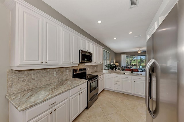 kitchen featuring white cabinets, backsplash, stainless steel appliances, ceiling fan, and sink