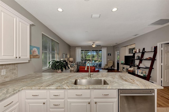 kitchen featuring ceiling fan, light stone countertops, sink, and white cabinetry