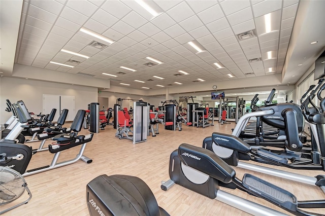 exercise room featuring a paneled ceiling and light hardwood / wood-style flooring