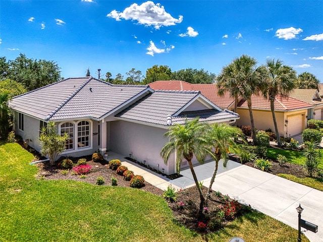 single story home featuring driveway, a tiled roof, an attached garage, stucco siding, and a front lawn