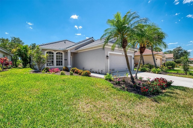 view of front of house with an attached garage, concrete driveway, stucco siding, a front yard, and a tiled roof