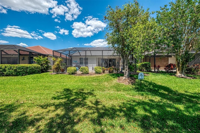back of property featuring a yard and glass enclosure