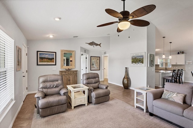 living room with ceiling fan, vaulted ceiling, and a healthy amount of sunlight