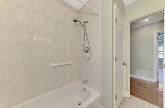 bathroom featuring tiled shower / bath combo and hardwood / wood-style floors