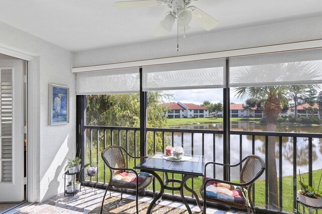 sunroom / solarium featuring a water view and ceiling fan