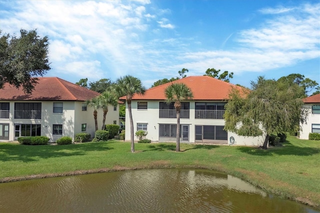 back of house with a yard and a water view