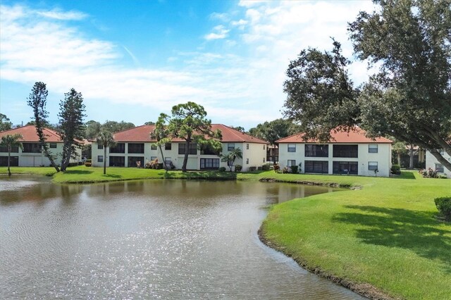 view of community with a lawn and a water view