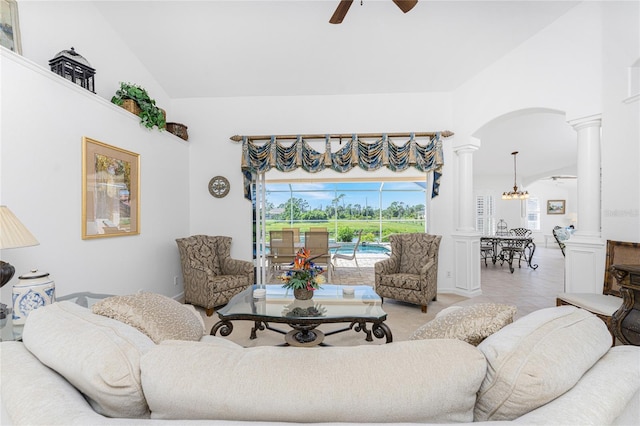 living room with lofted ceiling, ceiling fan, and ornate columns