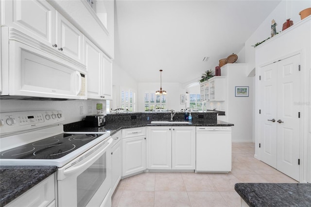 kitchen featuring white appliances, vaulted ceiling, sink, and white cabinets