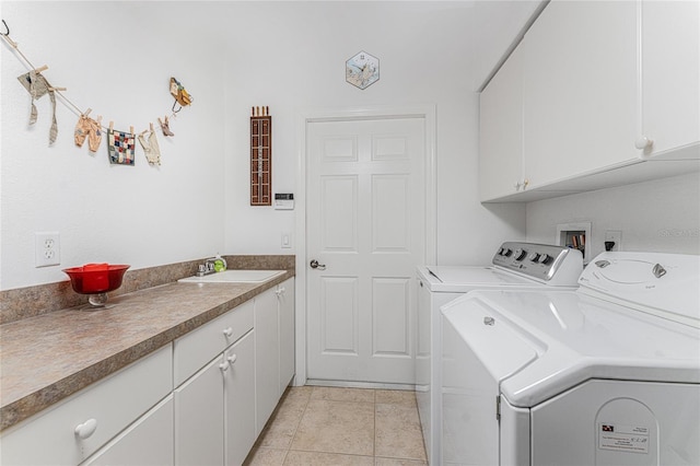 clothes washing area featuring cabinets, light tile patterned flooring, washer and dryer, and sink