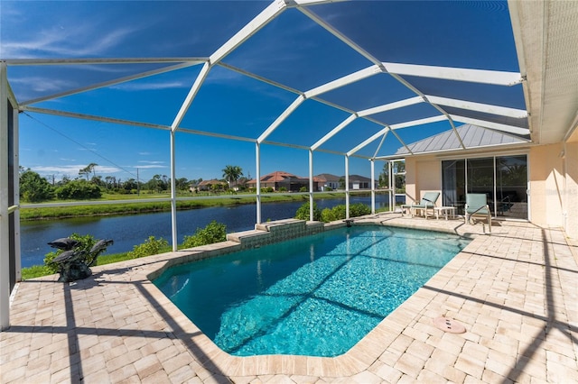 view of swimming pool with glass enclosure, a water view, and a patio area