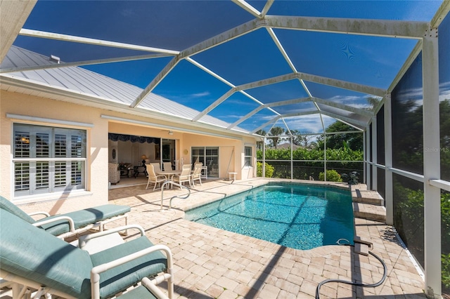 view of pool with a patio and glass enclosure