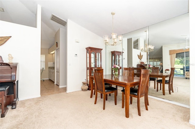 dining room featuring light carpet, an inviting chandelier, and high vaulted ceiling