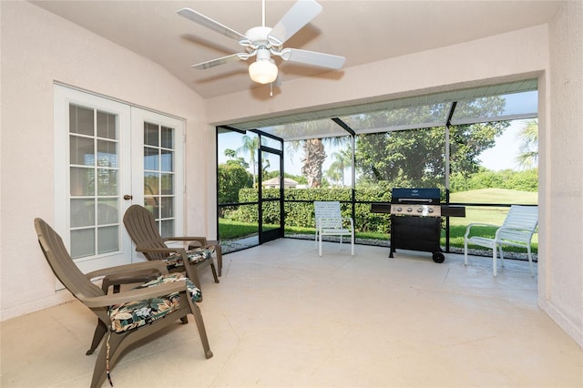 sunroom / solarium featuring lofted ceiling, ceiling fan, and french doors