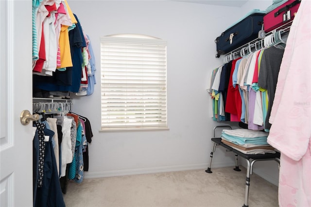 walk in closet with light colored carpet