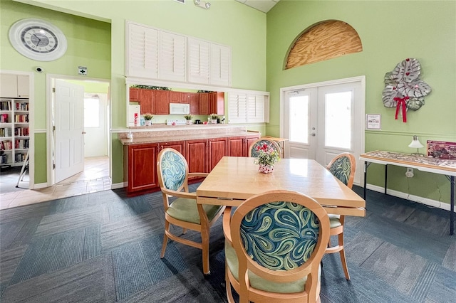 dining area featuring a high ceiling and french doors