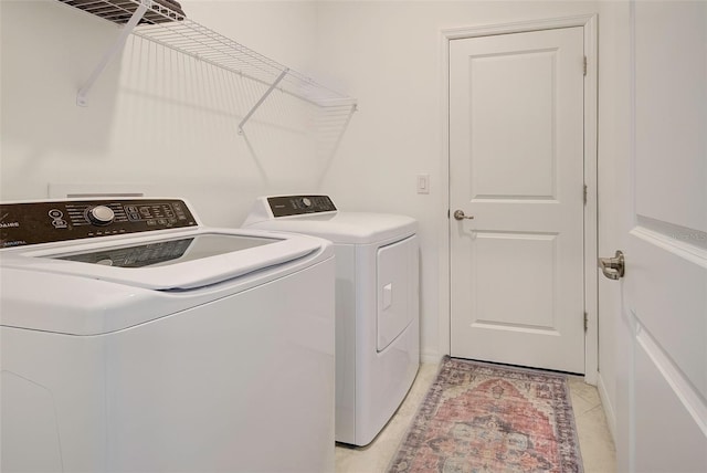 laundry room with washing machine and dryer and light tile patterned floors