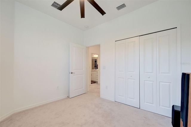 unfurnished bedroom with ceiling fan, light colored carpet, and a closet