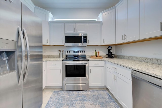 kitchen with light stone countertops, stainless steel appliances, and white cabinets