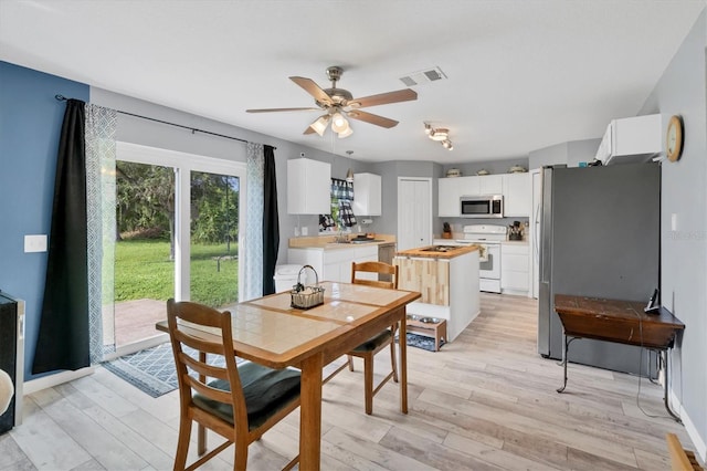 dining space featuring ceiling fan and light wood-type flooring