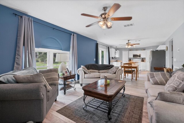 living room featuring ceiling fan and light hardwood / wood-style floors