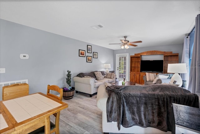 living room with light hardwood / wood-style floors and ceiling fan