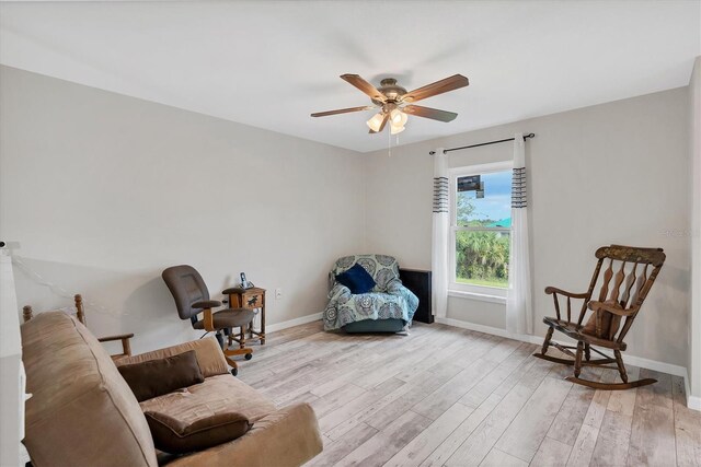 living area with ceiling fan and light hardwood / wood-style flooring