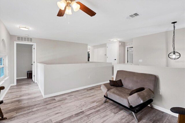 sitting room with ceiling fan and light hardwood / wood-style flooring