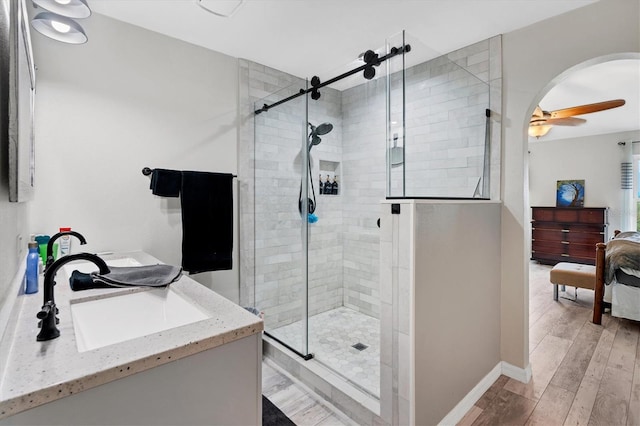 bathroom with ceiling fan, vanity, hardwood / wood-style floors, and a shower with door