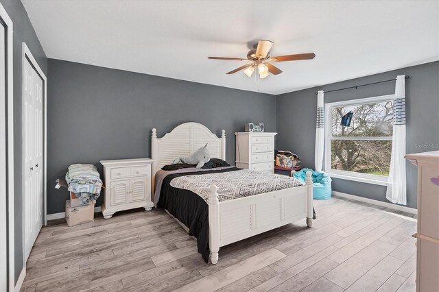 bedroom featuring a closet, light hardwood / wood-style floors, and ceiling fan