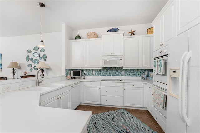 11100 Hacienda Del Mar Blvd Unit 202, Placida, FL 33946 - kitchen featuring white appliances, dark tile patterned floors, decorative backsplash, a sink, and a peninsula
