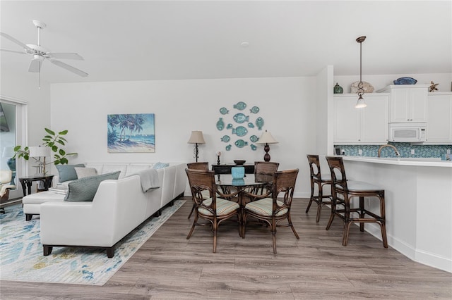 11100 Hacienda Del Mar Blvd Unit 202, Placida, FL 33946 - dining room featuring baseboards, ceiling fan, and light wood-type flooring