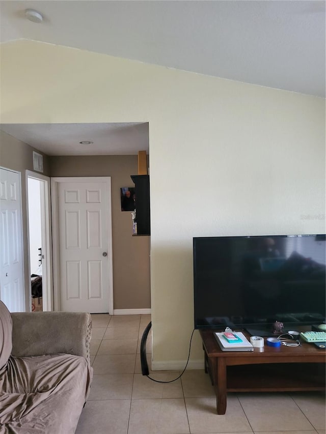 living room with light tile patterned floors and vaulted ceiling