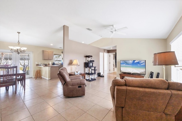 living area featuring light tile patterned floors, lofted ceiling, ceiling fan with notable chandelier, visible vents, and baseboards