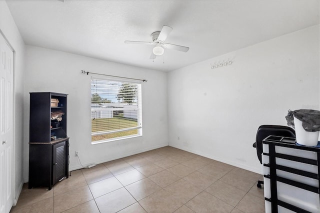 spare room with ceiling fan, light tile patterned floors, and baseboards