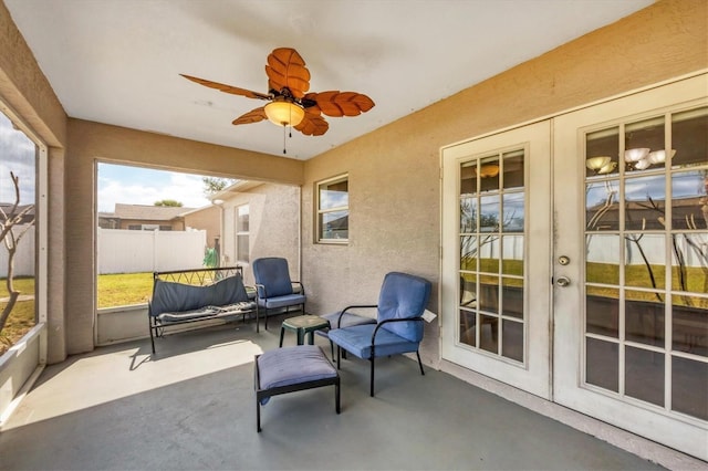 sunroom / solarium with a ceiling fan and french doors