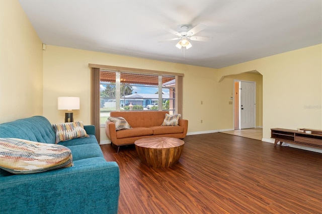 living room with ceiling fan and dark wood-type flooring