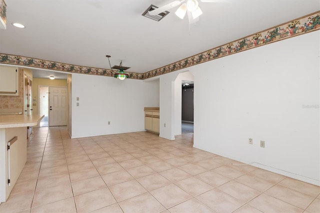 tiled spare room featuring ceiling fan