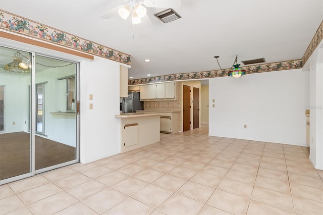 kitchen featuring decorative backsplash, white cabinetry, kitchen peninsula, ceiling fan, and stainless steel refrigerator with ice dispenser