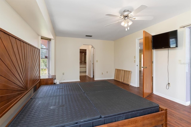 unfurnished bedroom with ensuite bath, ceiling fan, and dark hardwood / wood-style flooring