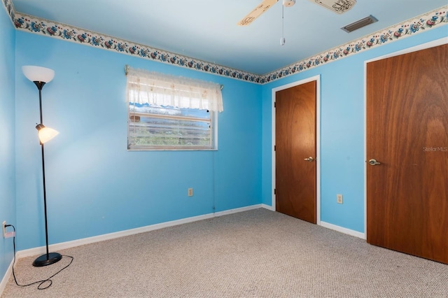 spare room featuring ceiling fan and carpet flooring