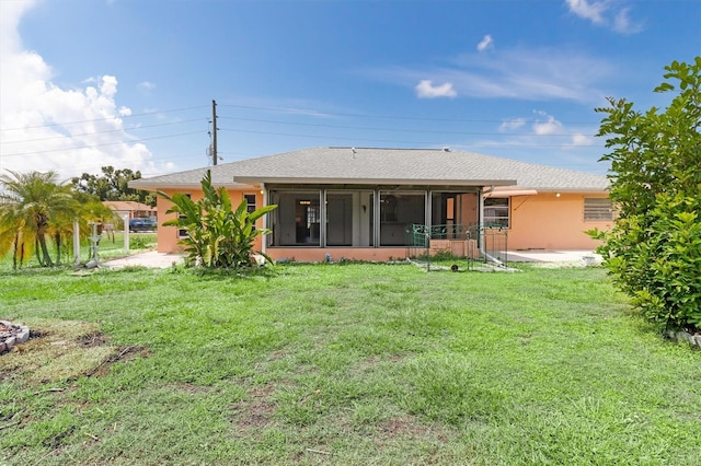 rear view of property with a sunroom and a yard