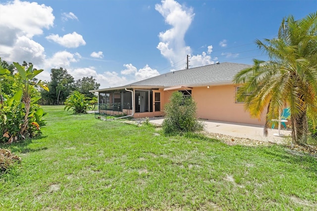 back of property featuring a yard, a sunroom, and a patio area