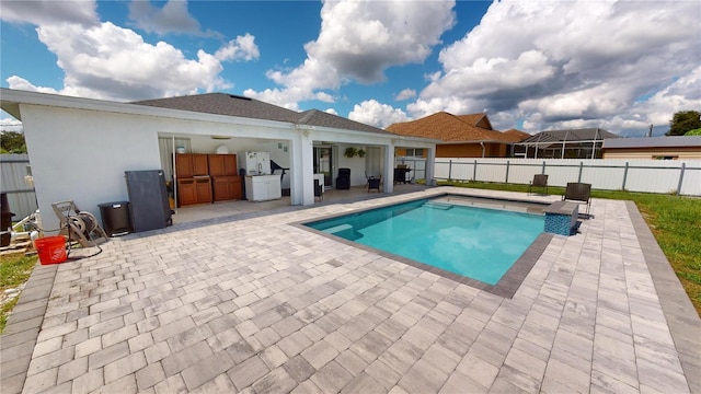 view of pool with a patio and an outdoor kitchen