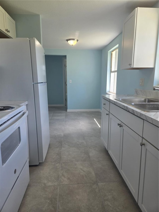 kitchen featuring white cabinetry, sink, and white range with electric cooktop