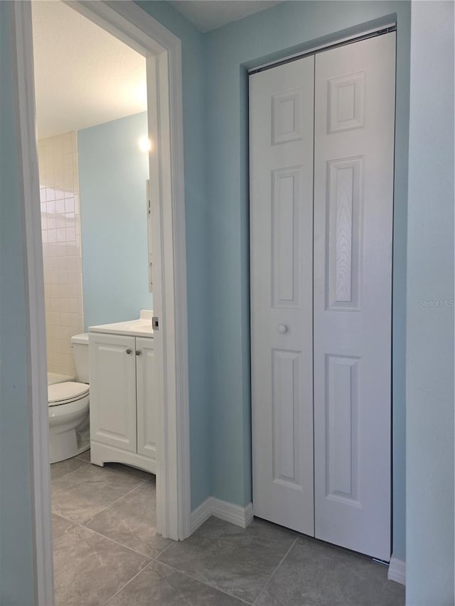 bathroom with vanity, toilet, and tile patterned floors